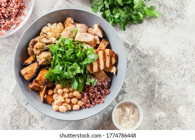 Buddha Bowl Lunch With Chicken And Red Rice, Chickpea, Cauliflower And Halloumi Cheese. Healthy Food Concept