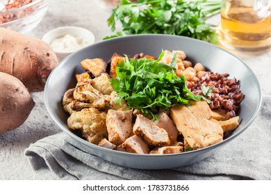 Buddha Bowl Lunch With Chicken And Red Rice, Chickpea, Cauliflower And Halloumi Cheese. Healthy Food Concept