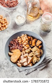 Buddha Bowl Lunch With Chicken And Red Rice, Chickpea, Cauliflower And Halloumi Cheese. Healthy Food Concept