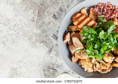 Buddha Bowl Lunch With Chicken And Red Rice, Chickpea, Cauliflower And Halloumi Cheese. Healthy Food Concept