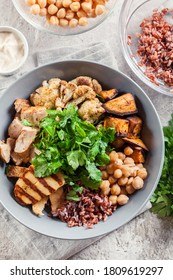 Buddha Bowl Lunch With Chicken And Red Rice, Chickpea, Cauliflower And Halloumi Cheese. Healthy Food Concept