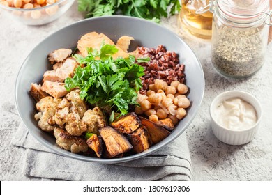 Buddha Bowl Lunch With Chicken And Red Rice, Chickpea, Cauliflower And Halloumi Cheese. Healthy Food Concept