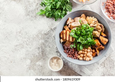 Buddha Bowl Lunch With Chicken And Red Rice, Chickpea, Cauliflower And Halloumi Cheese. Healthy Food Concept