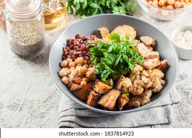 Buddha Bowl Lunch With Chicken And Red Rice, Chickpea, Cauliflower And Halloumi Cheese. Healthy Food Concept