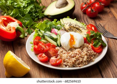 Buddha Bowl With Mixture Of Vegetables, Quinoa, Poached Egg  On Wooden Background