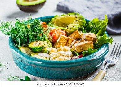 Buddha Bowl With Quinoa, Tofu, Avocado, Sweet Potato, Brussels Sprouts And Tahini. Healthy Vegan Food Concept.