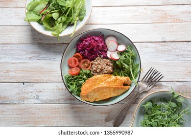Buddha bowl with red cabbage, cherry tomatoes, radish, arugula beet leaves, pea shoots, buckwheat and grilled chicken. Healthy food concept