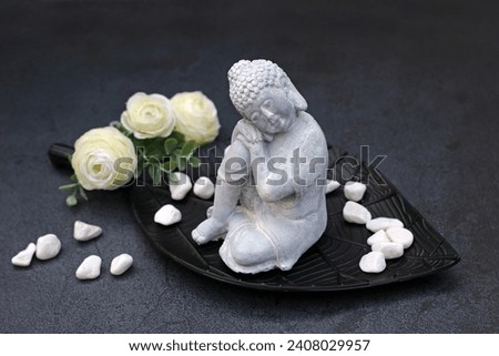 Buddha figure with roses and decorative stones.