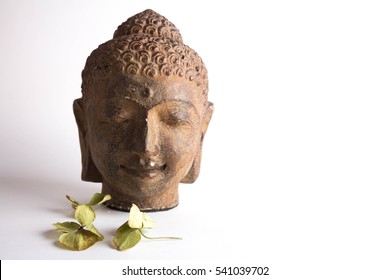 Buddha head statue with flowers isolated on white background