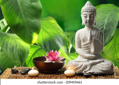 Buddha in meditation with lotus flower and burning candles - Powered by Shutterstock