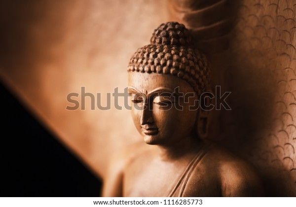 Buddha\
in a meditation pose, under protection of the king of nag -\
Mukalinda. Figure isolated on a black\
background.