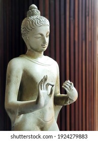 Buddha statue in front of wooden wall