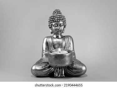 buddha statue with lit candle. black background - Powered by Shutterstock