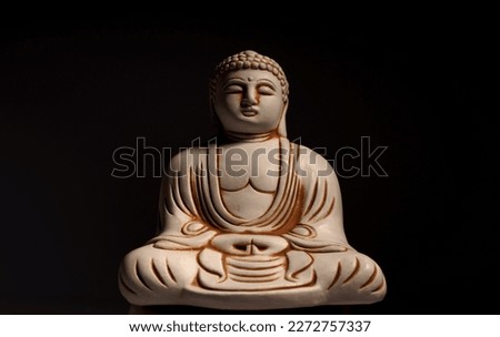 Buddha statue on a black background. Ancient figurine         