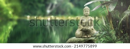 buddha statue on a rock lakeside, natural spa background with asian spirit, tranquility in green nature, web banner concept with copy space