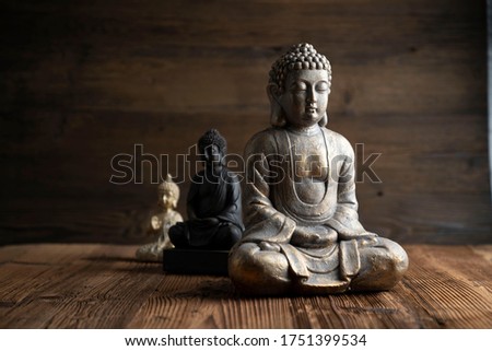 Buddhism concept image. Buddha statue on rustic wooden table.