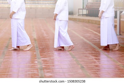 Buddhism In White Cloth Practicing Meditation By Tranquil Walk. Woman In White Cloth Buddhism Walking In Temple For Meditation. Nun, Female Priestess Does Jong Krom