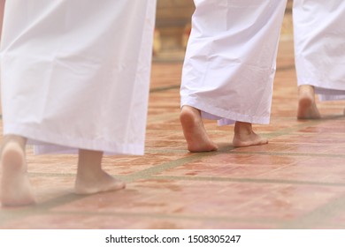 Buddhism In White Cloth Practicing Meditation By Tranquil Walk. Woman In White Cloth Buddhism Walking In Temple For Meditation. Nun, Female Priestess Does Jong Krom