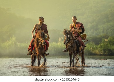 Buddhist monk with brown robe ride horse and ask for alms (Unseen in Thailand) ,A tree beside way that people riding horses in the countrysid  at Chiangrai ,Thailand 