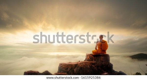 Buddhist monk in meditation at beautiful\
sunset or sunrise background on high\
mountain
