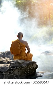 Buddhist Monk In Meditation In Nature Amidst The Hot Sun .