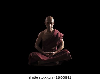 buddhist monk in meditation pose over black background