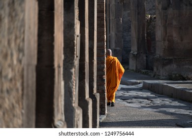 Buddhist Monk Walking Away In The Streets Of Pompeii
