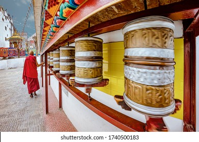 A Buddhist monk walking and spinning the buddhist prayer wheels at Gonpa Soma monastery in Leh, India