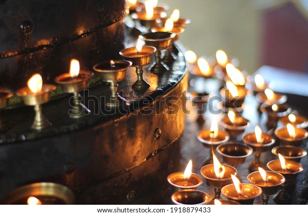 Buddhist Old Altar Candles at\
Religious 108 Butter Lamp Festival in Temple Monastery. Beautiful\
Tranquil Scenic View of Oil Lamps and Swaying Flame for Praying\
