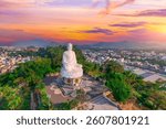 Buddhist temple in the city of Nha Trang in south Vietnam morning sunset beautiful orange sky view. Big Buddha statue at the Long Son Pagoda or Chua Long Son.