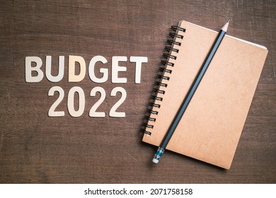 Budget 2022 text by wooden letters with small notebook and pencil, budget and investment plan in 2022