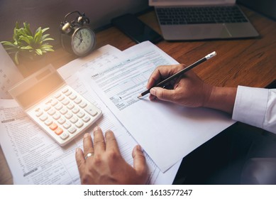 Budget Planning Concept, Accountant Is Calculating Tax. Calendar 2020 And Personal Income Annual Tax Forms For Those Who Have Income Under US Law Placed On Office Desk