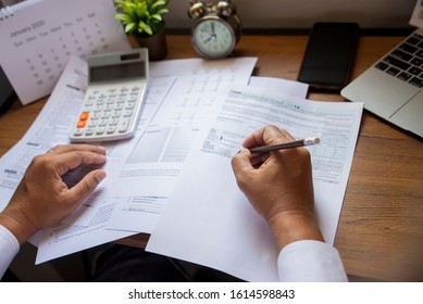 Budget Planning Concept,Accountant Is Calculating Company's Annual Tax.Calendar 2022 And Personal Income Tax Forms For Those Who Have Income Under US Law Placed On Office Desk.