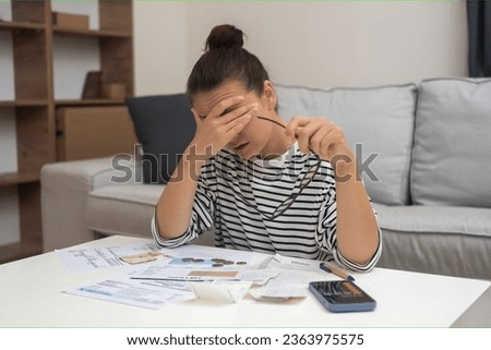 Budgetary Woes: Unhappiness looms as a woman wrestles with debt, navigating household finances, and calculating expenses for online payments. 