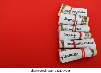 Budgeting money with  envelope method by set specific amount for monthly spending  - each cash wrapped with red rubber bands for each categories of expenses - on red background with copy space. - Shutterstock ID 1321799258