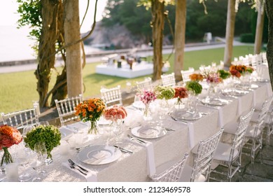 Budva, Montenegro - 15.07.21: Wedding dinner table reception. Under the old columns with vines of wisteria.