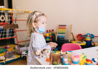 Budva, Montenegro - 17 march 2021: Child girl in a protective mask playing in kindergarten. - Shutterstock ID 1938504406