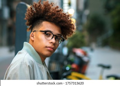 Buenos Aires, Argentina - April 24th 2019: Young man with glasses and curly hair in urban shoot.