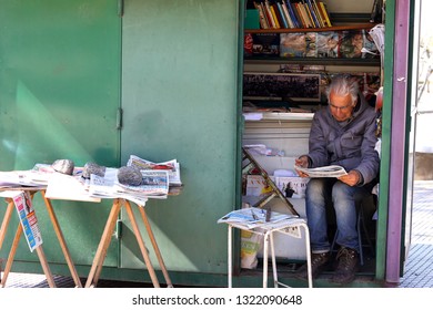 Buenos Aires, Argentina - August 22, 2018: Unidentified Newstand Clerk Reading The Newspaper In Buenos Aires, Argentina