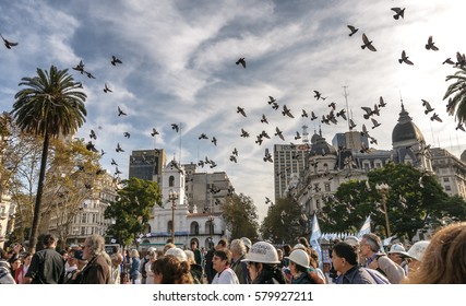Buenos Aires, Argentina. Circa May 2008. View of  protesters march in Plaza de Mayo square in downtown Buenos Aires, with historic Cabildo building in the background and pigeons flying above.
