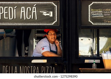 Buenos Aires, Argentina - December 16, 2018: Female Cashier Waits For Customers In The Window Of A Food Truck During A Food Fest