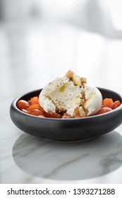 Buffalo Burrata Mozzarella Cheese Ball With Cocktail Tomatoes, Olive Oil And Balsamic Vinegar On Black Plate