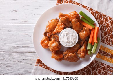 Buffalo Chicken Wings With Cheese Sauce And Celery On The Table. Horizontal View From Above
