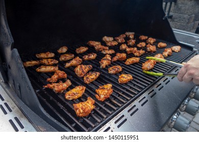 Buffalo Chicken Wings Cooking On A Summer BBQ On A Propane Gas Grill