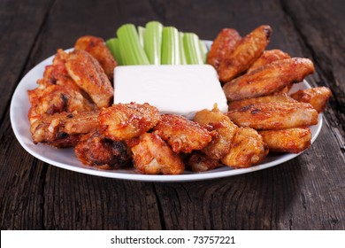 Buffalo Chicken Wings On Plate With Blue Cheese Sauce And Celery.