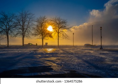 Buffalo New York Outer Harbor winter weather landscape misty snow covered trees sunset.