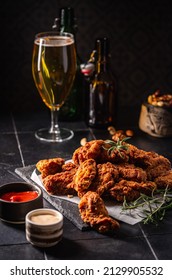 Buffalo style chicken wings served with cold beer on dark background