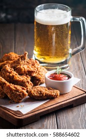 Buffalo style chicken wings served with cold beer on wooden background