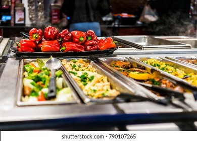 Buffet bar and trays with roasted salad vegetables, red bell peppers and meat dishes