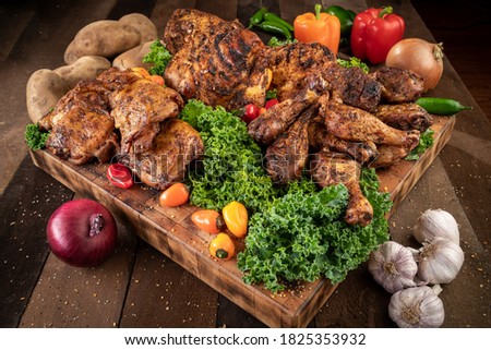 A buffet of Chicken on a rustic cutting board surrounded by various condiments.
